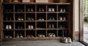 Several pairs of shoes arranged at different distances from the step inside a Japanese genkan, suggesting varying degrees of closeness and belonging.